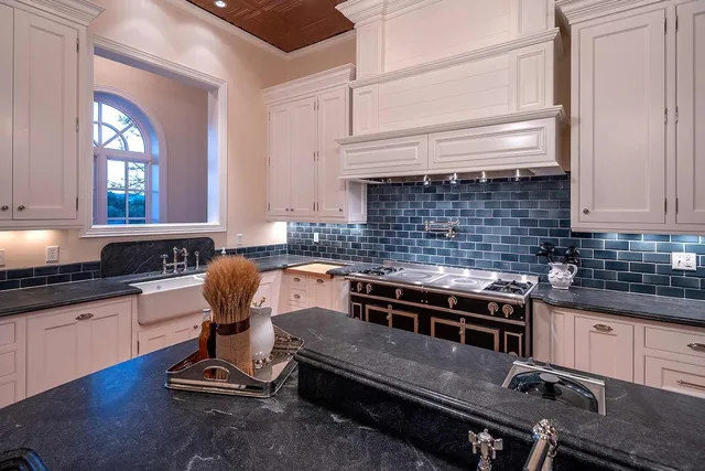 a kitchen with a stove a sink and cabinets