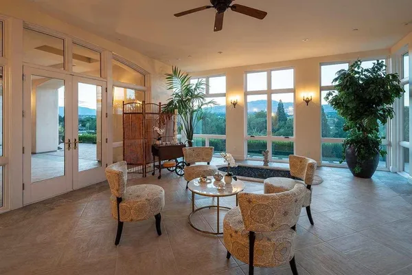 a living room with patio furniture and a potted plants