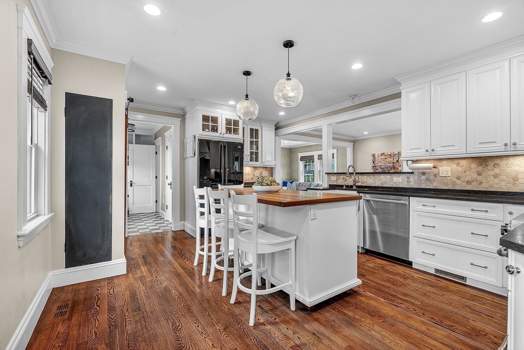 3 Thorpe Road Needham, MA 02494 - Photo 12 of 36 a kitchen with kitchen island granite countertop a sink cabinets and wooden floor