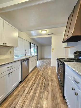 a kitchen with a sink and wooden floor