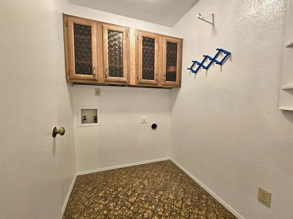 a view of a hallway with wooden floor and a cabinet