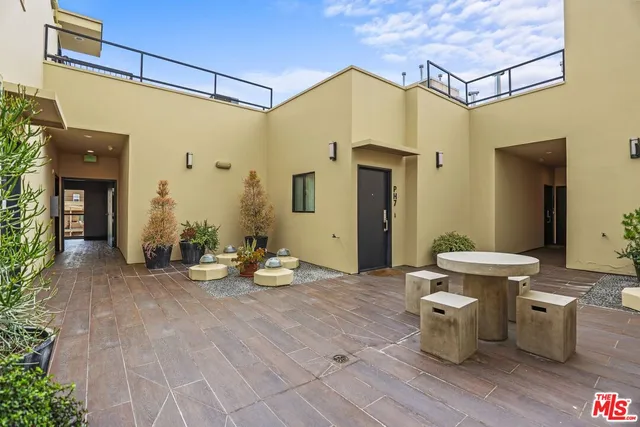 a view of a patio with table and chairs and potted plants