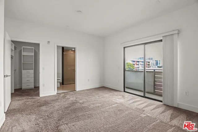 an empty room with closet and windows