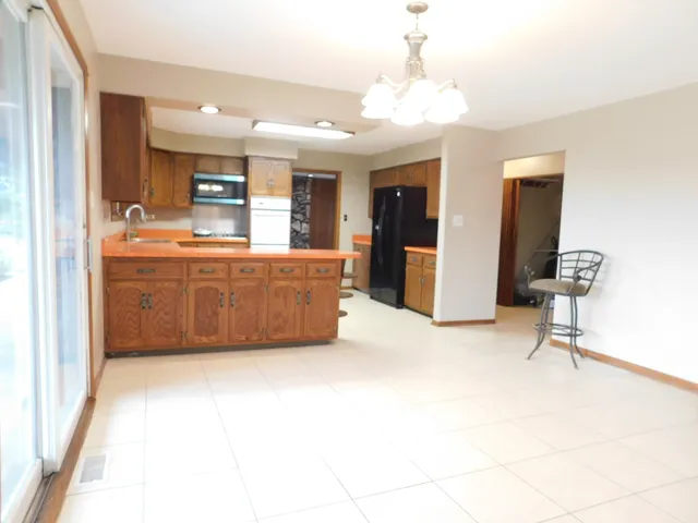 a large room with chandelier fan and a view of living room