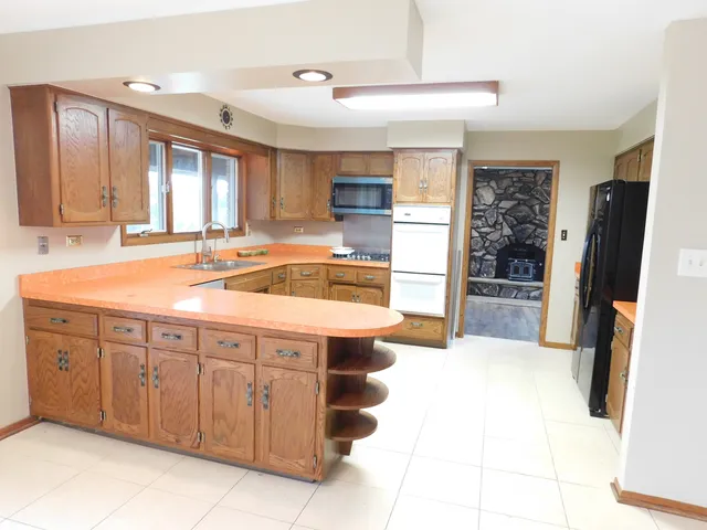 a kitchen with stainless steel appliances granite countertop a refrigerator and a sink