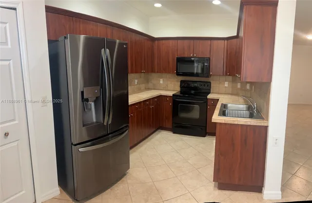 a kitchen with stainless steel appliances granite countertop a refrigerator and a stove top oven