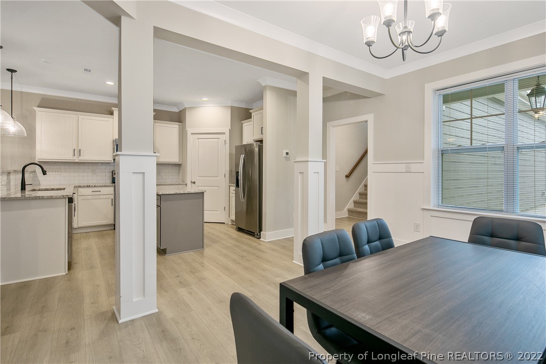 36 Spruce Hollow Circle Spring Lake, NC 28390 - Photo 10 of 49 a kitchen with stainless steel appliances granite countertop a refrigerator a sink dishwasher a dining table and chairs with wooden floor