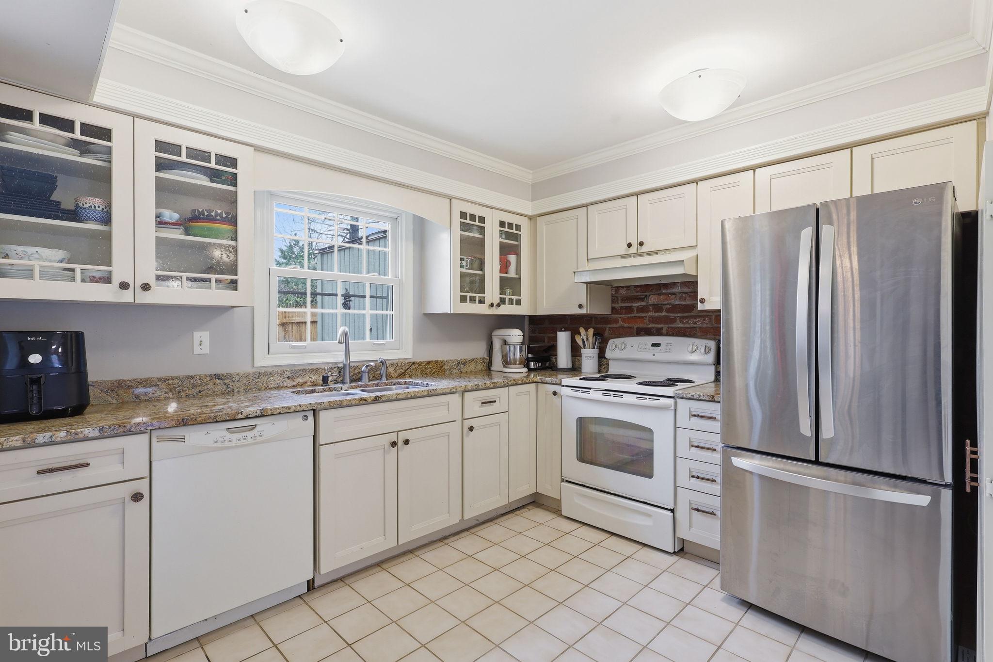 8222 Carrleigh Parkway, Unit 12 Springfield, VA 22152 - Photo 12 of 22 a kitchen with granite countertop white cabinets and white stainless steel appliances