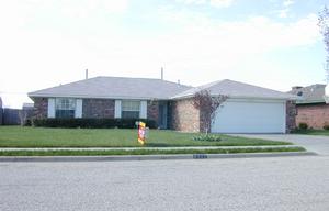 a front view of a house with a garden and yard