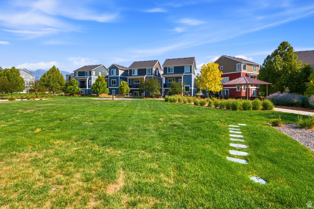 862 Founders Point Lane South Midvale, UT 84047 - Photo 41 of 45 Expansive green space with stepping stone path, surrounding landscaping, and distant mountain backdrop