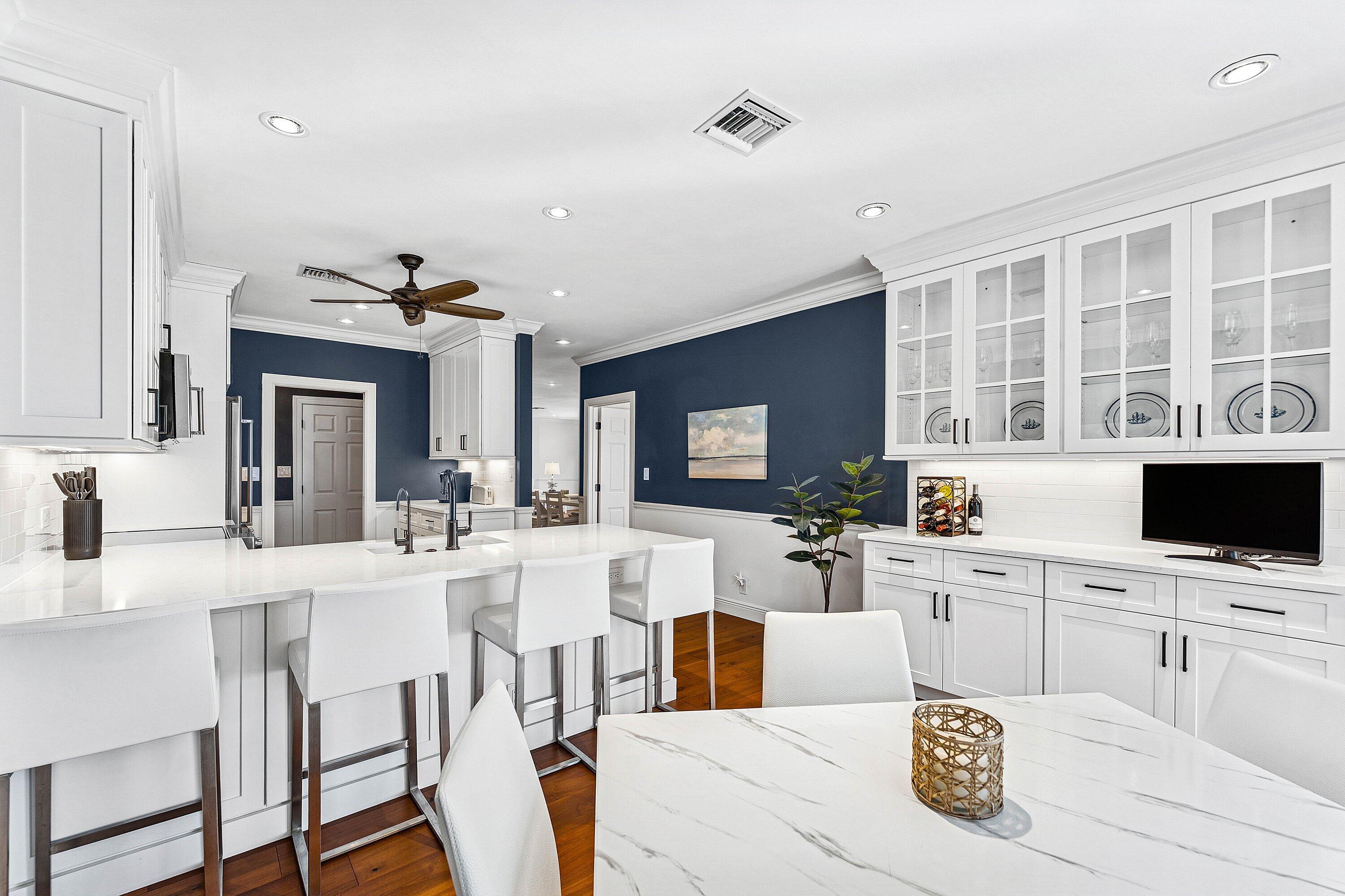 5900 Old Ocean Boulevard, Unit C4 Ocean Ridge, FL 33435 - Photo 8 of 25 a kitchen with stainless steel appliances kitchen island granite countertop a stove a sink a dining table and chairs