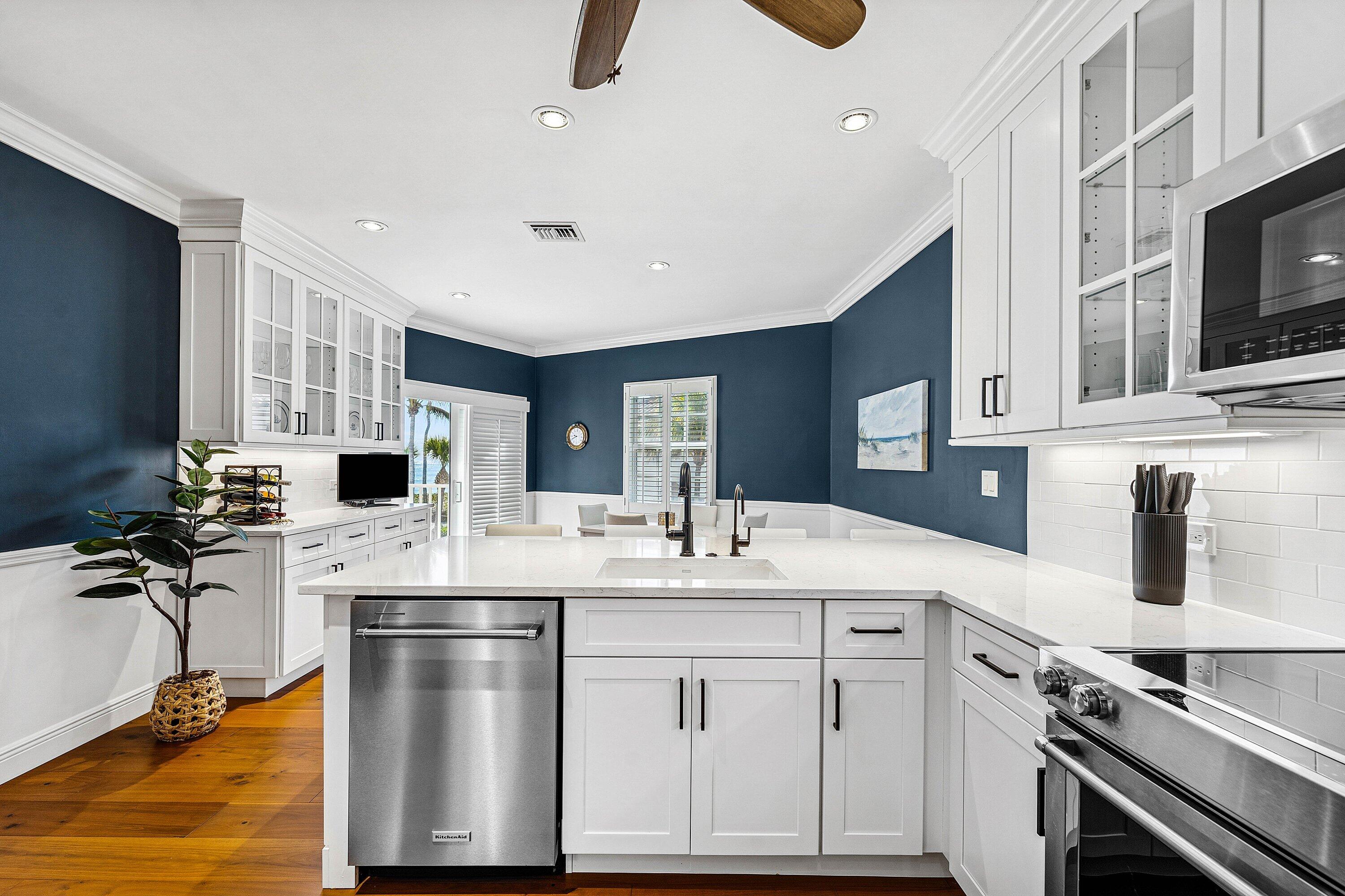 5900 Old Ocean Boulevard, Unit C4 Ocean Ridge, FL 33435 - Photo 10 of 25 a kitchen with a sink stainless steel appliances and white cabinets
