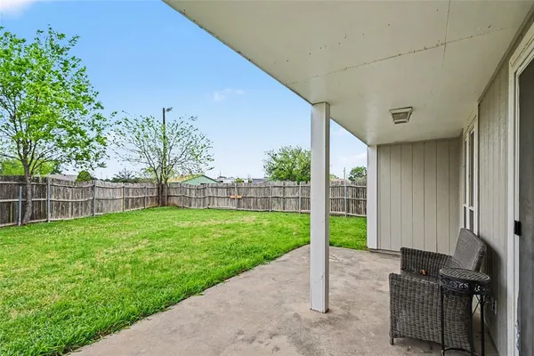 a view of a backyard with couches plants and large tree