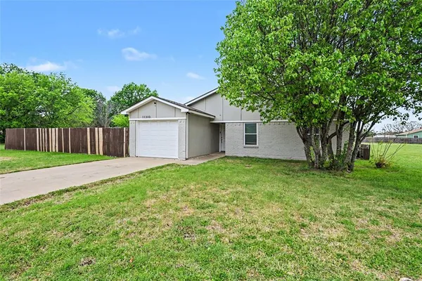 a view of a house with yard and a large tree