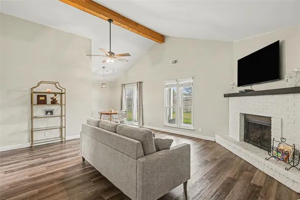 a living room with furniture a flat screen tv and a fireplace