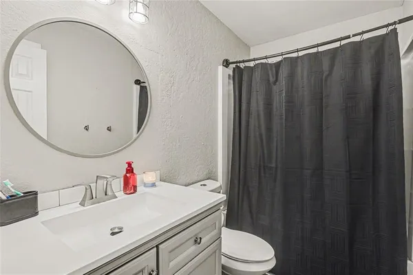 a bathroom with a sink vanity mirror and toilet