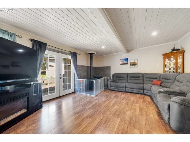 a kitchen with stainless steel appliances granite countertop a refrigerator a sink dishwasher a stove and white countertops with wooden floor