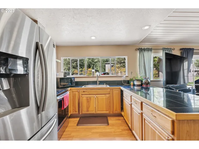 a kitchen with stainless steel appliances a refrigerator and a counter space