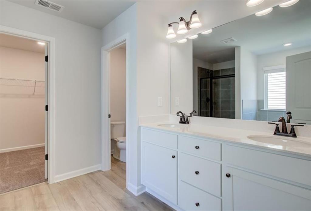 123 St Anne's Place Covington, GA 30016 - Photo 18 of 21 a bathroom with a double vanity sink a mirror and a shower