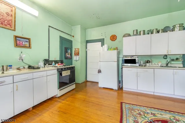 a kitchen with a refrigerator and countertop cabinets