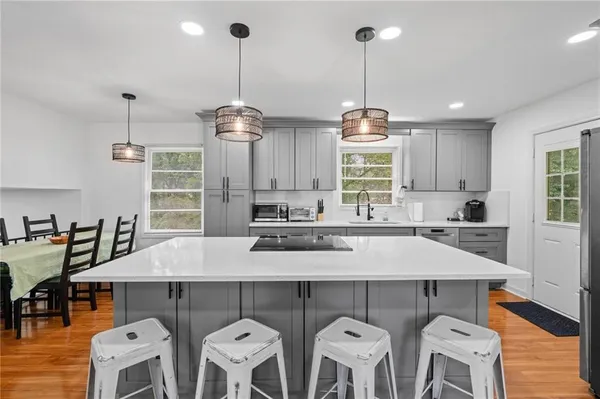 a kitchen with stainless steel appliances a dining table chairs and white cabinets