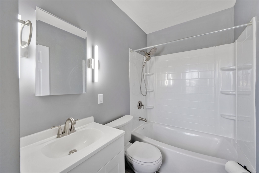 41 Briggs Street Springfield, MA 01151 - Photo 7 of 30 a bathroom with a bathtub shower sink vanity and toilet