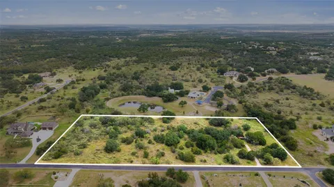 an aerial view of residential houses with outdoor space and trees