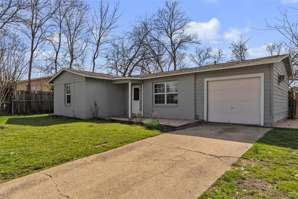 a backyard of a house with large trees and garage