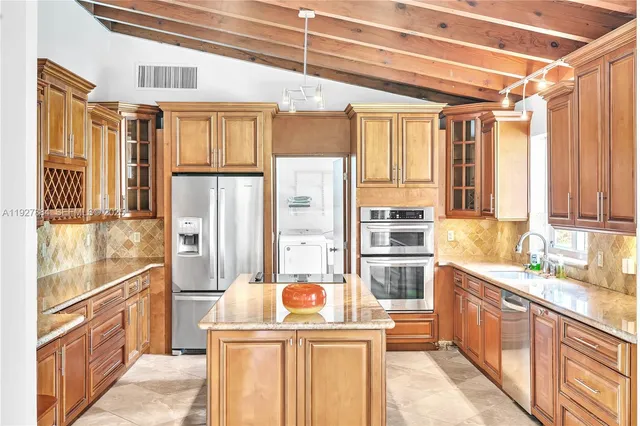 a kitchen with stainless steel appliances granite countertop a sink window and refrigerator