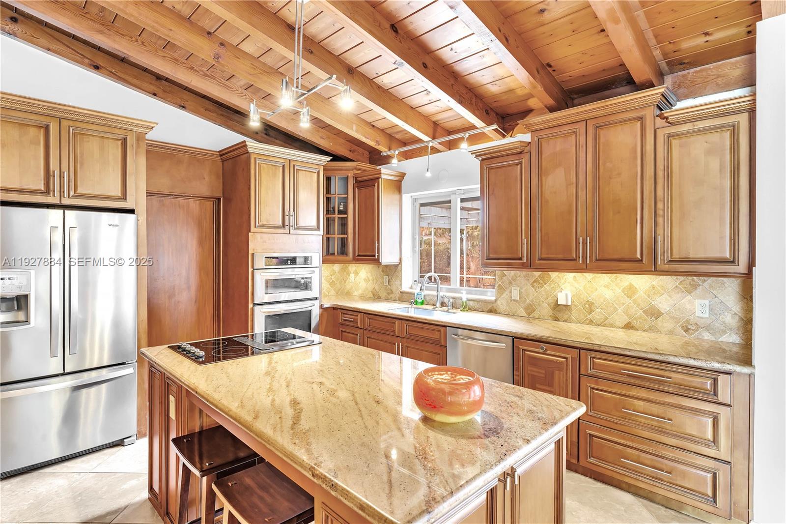 3437 Buchanan Street Hollywood, FL 33021 - Photo 18 of 40 a kitchen with stainless steel appliances granite countertop a sink window and refrigerator