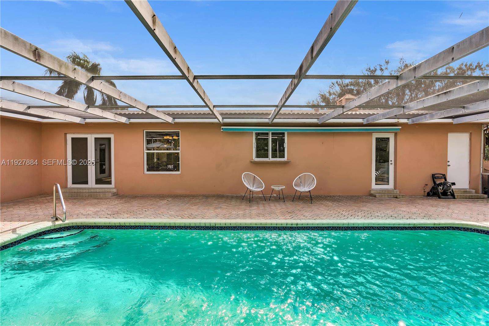3437 Buchanan Street Hollywood, FL 33021 - Photo 25 of 40 a backyard of a house with table and chairs