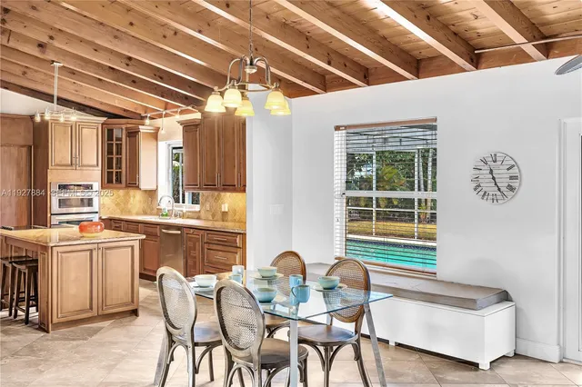 a view of a dining room with furniture a chandelier and wooden floor