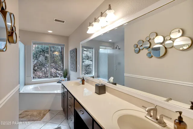 a bathroom with a granite countertop sink a large mirror and a bathtub with shower