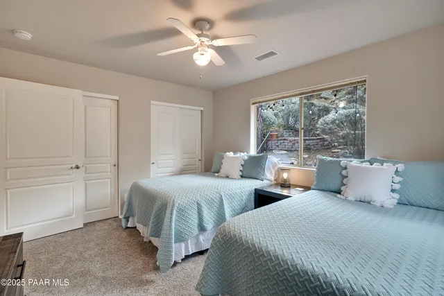 a bedroom with two beds and a large window