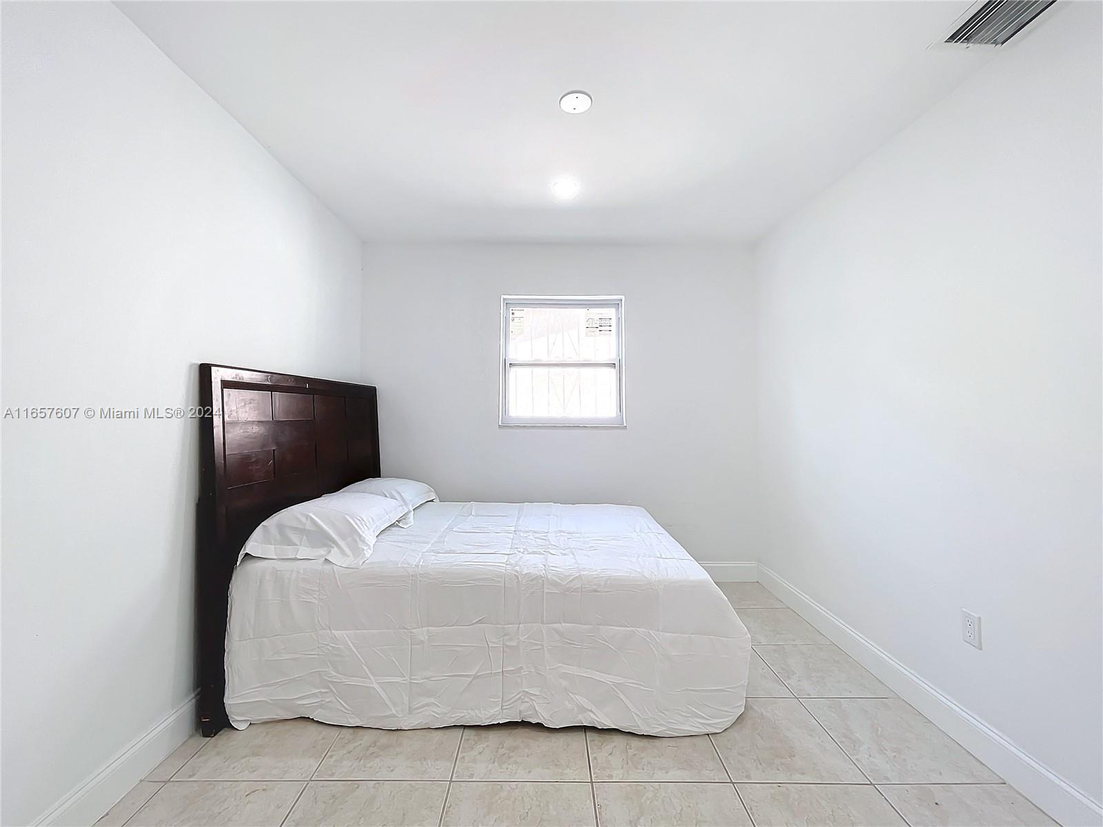 8218 Southampton Drive Miramar, FL 33025 - Photo 24 of 28 a bedroom with a bed and window