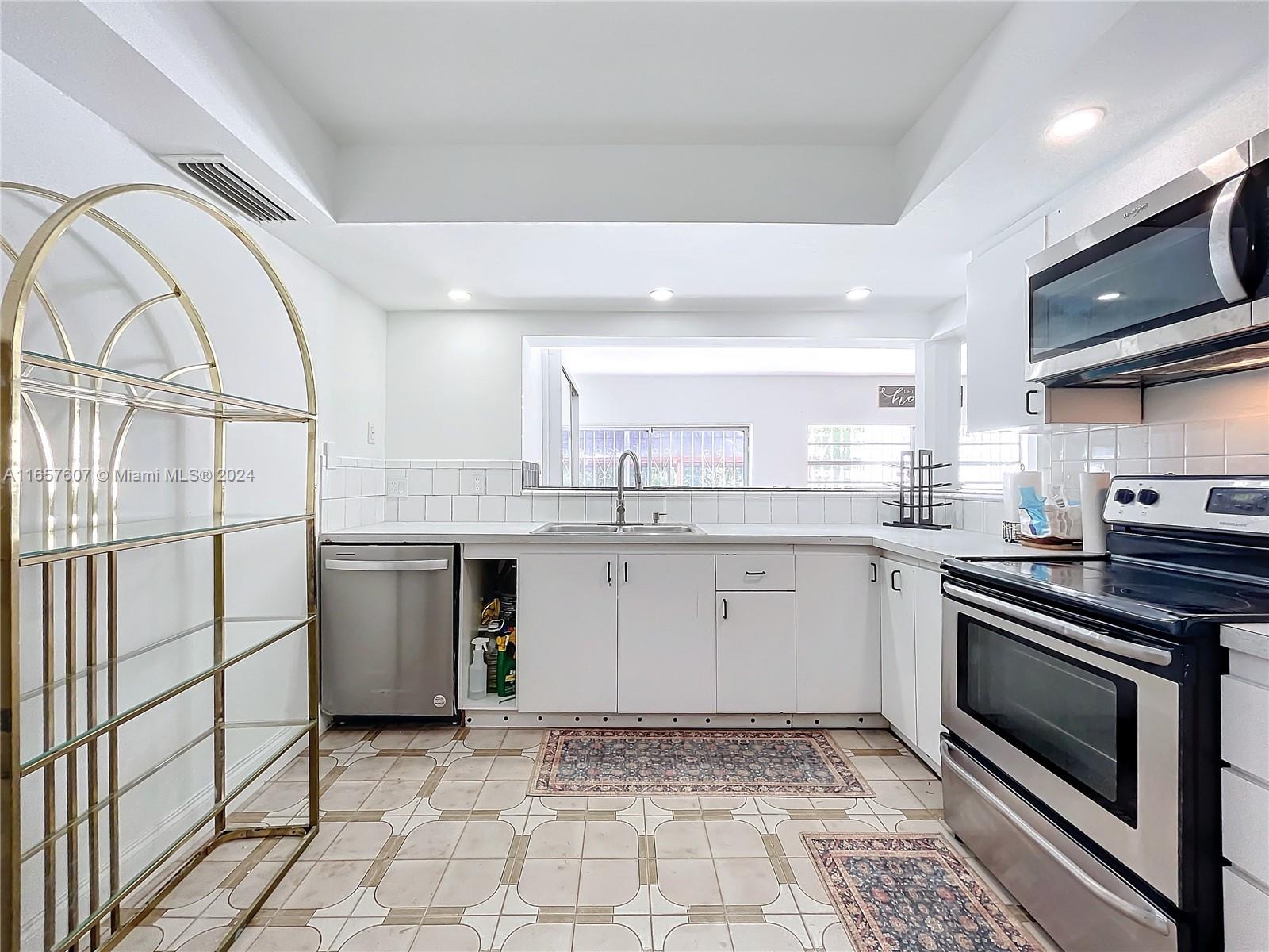 8218 Southampton Drive Miramar, FL 33025 - Photo 9 of 28 a kitchen with a stove a sink and a microwave