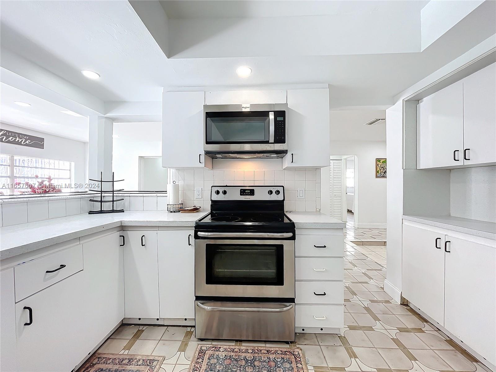 8218 Southampton Drive Miramar, FL 33025 - Photo 10 of 28 a kitchen with white cabinets and appliances