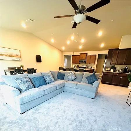 a living room with furniture kitchen view and a chandelier