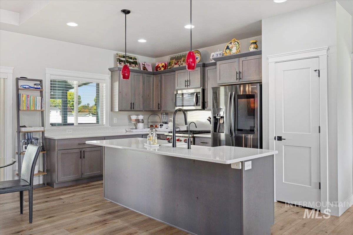 1436 Jump Street Twin Falls, ID 83301 - Photo 11 of 35 Kitchen with stainless steel appliances, a kitchen island with sink, pendant lighting, light wood finished floors, and recessed lighting