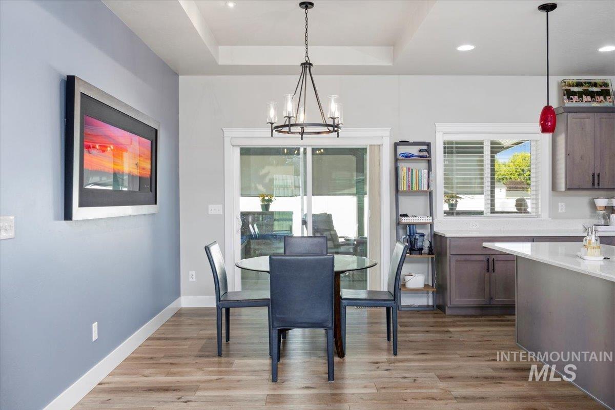 1436 Jump Street Twin Falls, ID 83301 - Photo 12 of 35 Dining room featuring a chandelier, light wood-type flooring, and a raised ceiling