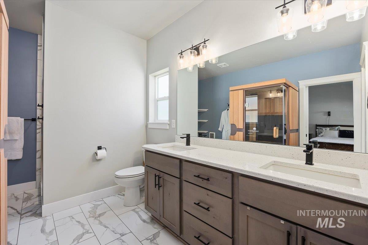 1436 Jump Street Twin Falls, ID 83301 - Photo 17 of 35 Full bathroom featuring double vanity, light marble finish floors, and ensuite bath