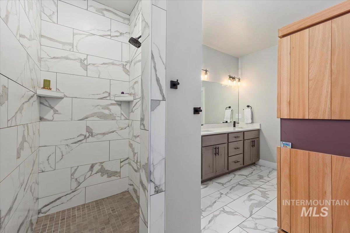1436 Jump Street Twin Falls, ID 83301 - Photo 19 of 35 Full bathroom featuring double vanity, light marble finish flooring, and a marble finish shower