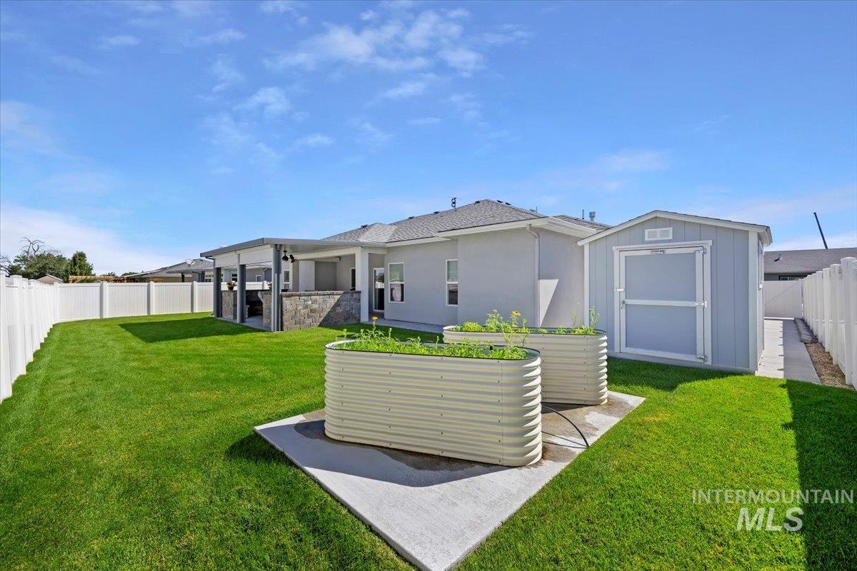 1436 Jump Street Twin Falls, ID 83301 - Photo 29 of 35 Rear view of property with a fenced backyard, a storage unit, a patio, and stucco siding