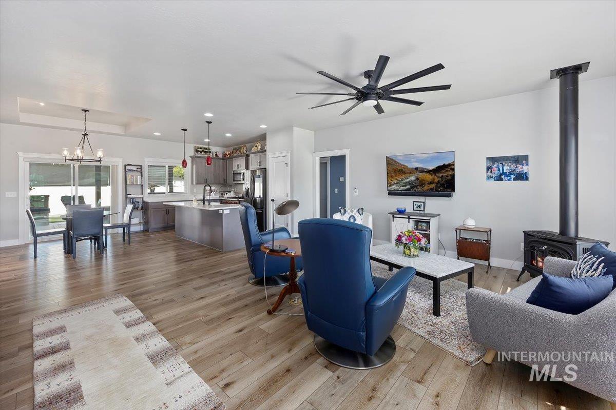 1436 Jump Street Twin Falls, ID 83301 - Photo 3 of 35 Living room featuring a wood stove, recessed lighting, a chandelier, a ceiling fan, and light wood-type flooring