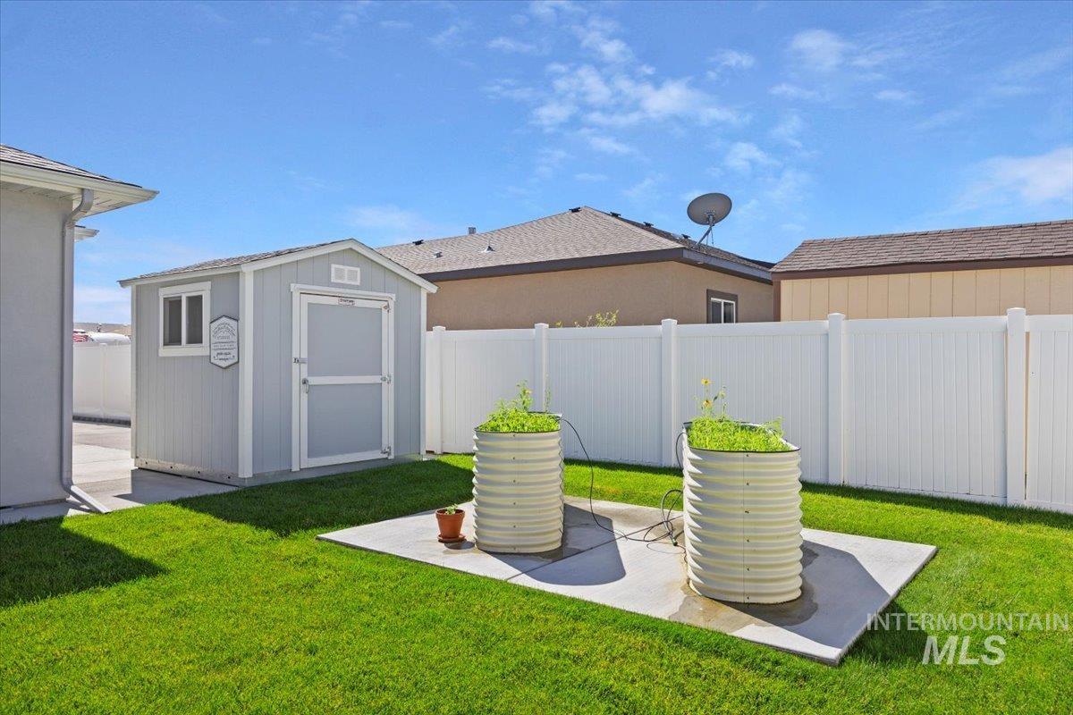 1436 Jump Street Twin Falls, ID 83301 - Photo 31 of 35 Fenced backyard with a storage unit and a patio