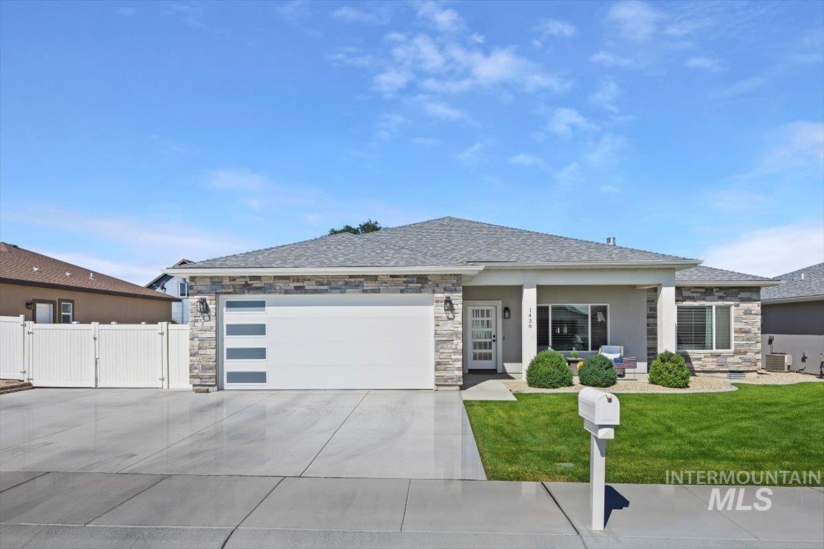 1436 Jump Street Twin Falls, ID 83301 - Photo 34 of 35 Prairie-style house featuring a garage, concrete driveway, a gate, stone siding, and a front yard