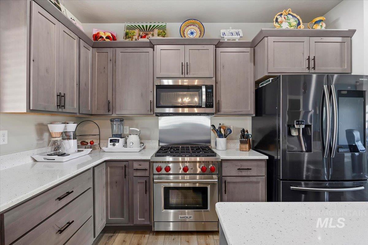 1436 Jump Street Twin Falls, ID 83301 - Photo 10 of 35 Kitchen featuring appliances with stainless steel finishes, light stone counters, and light wood-style flooring
