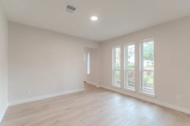 an empty room with a window and a fan