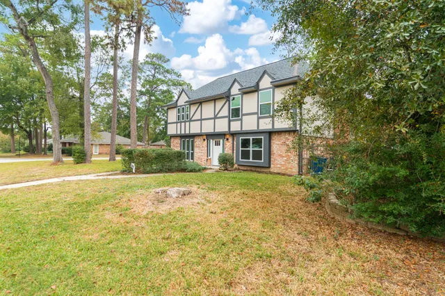 a view of a livingroom with a chandelier fan and windows