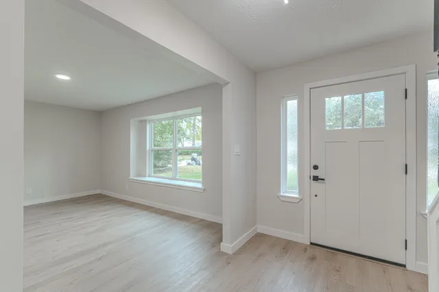 an empty room with wooden floor and fireplace